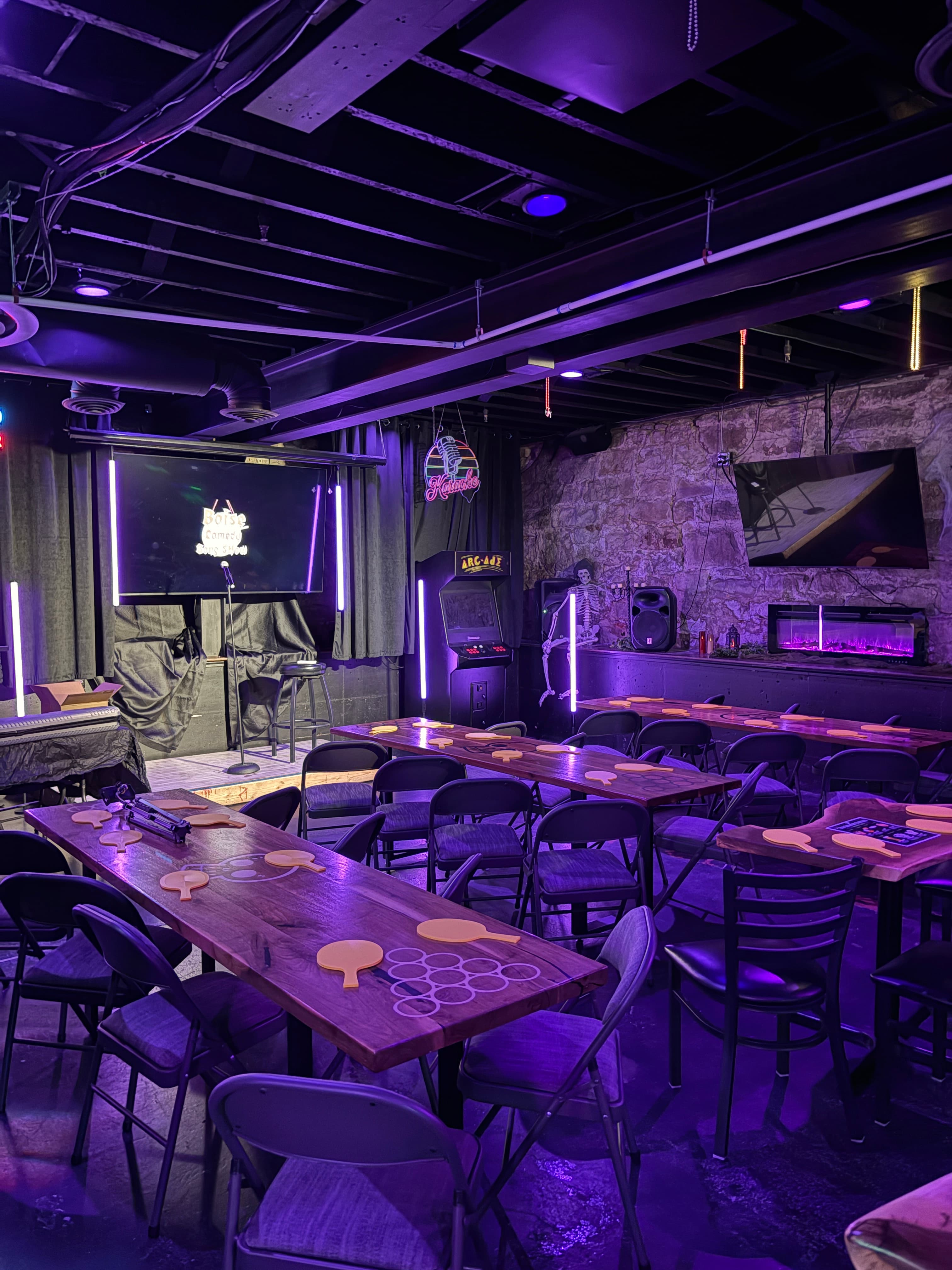 The intimate Voodoo Cellar comedy venue, lit in purple with a microphone on stage